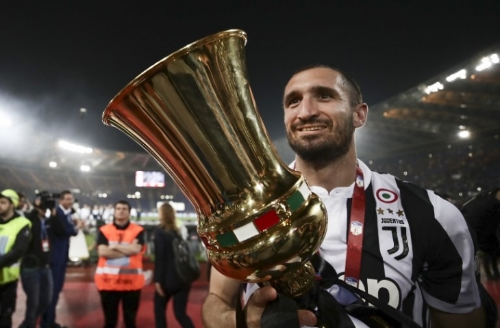 Bek Juventus, Giorgio Chiellini memegang trofi Coppa Italia (9/5) [Isabella Bonotto/AFP]