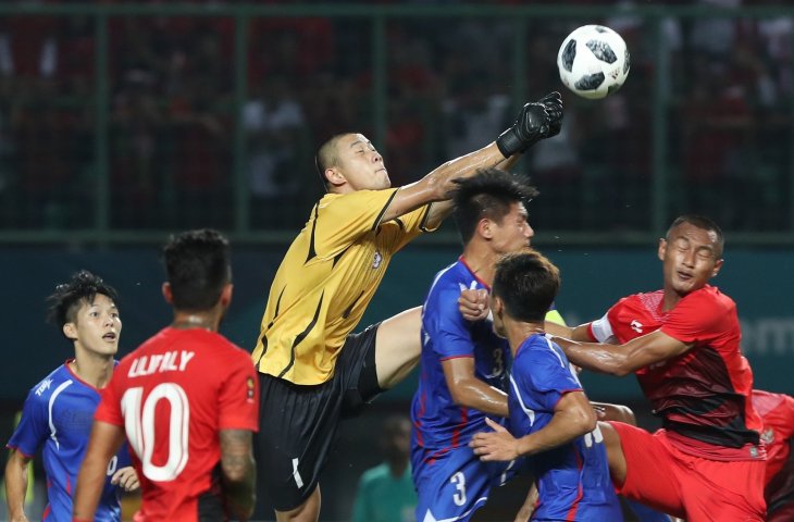 Penjaga gawang Taiwan Wenchieh Pan (tengah) berhasil menggagalkan serangan pemain Indonesia pada pertandingan Grup A Asian Games ke-18 di Stadion Patriot, Bekasi Minggu (12/8). (INASGOC/Charlie)