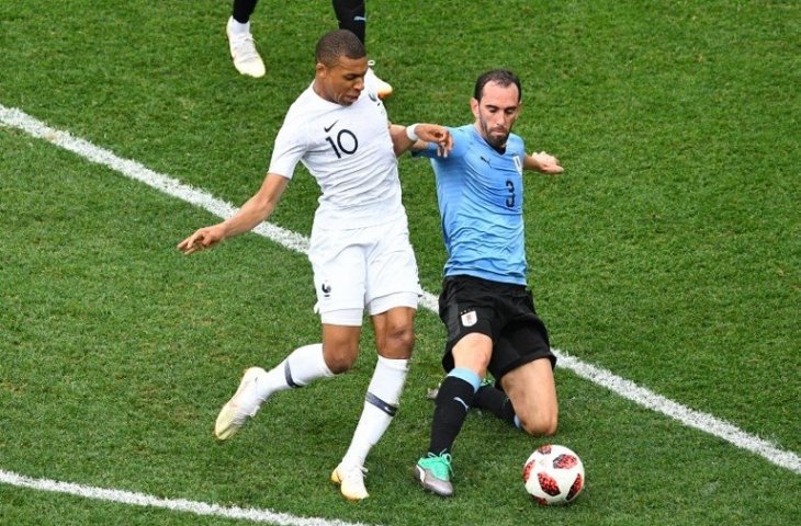 Aksi Diego Godin menghentikan Kylian Mbappe di Piala Dunia 2018 (Johannes Eisele/AFP)