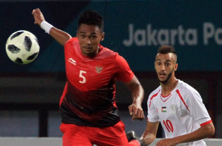 Pemain Timnas Indonesia Nugroho Bagas Adi (kiri) dengan pesepak bola Palestina, Yousef Mahmoud dalam pertandingan babak penyisihan sepak bola grup A Asian Games ke 18 di Stadion Patriot, Bekasi, Rabu (15/8). (INASGOC/Hery Sudewo)