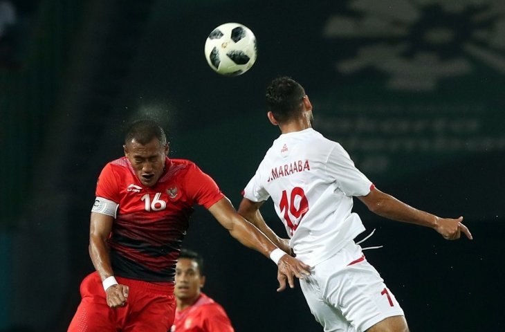 Pemain timnas Indonesia Hansamu Yama (kiri) menghadang serangan pemain Palestina Sameh Maraaba (dua dari kanan) pada pada babak penyisihan sepakbola Grup A Asian Games 2018 di Stadion Patriot Bekasi, Selasa (15/08). (INASGOC/Charlie)