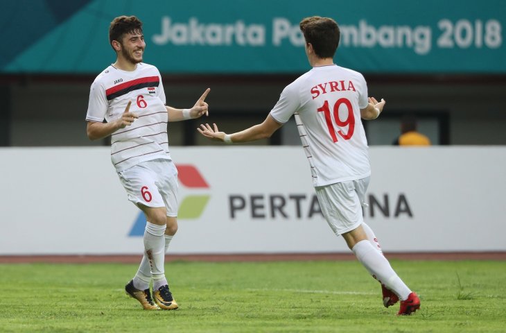 Pemain timnas Suriah Ahmad Ashkar (kiri) saat merayakan golnya kegawang Palestina a pada babak 16 besar cabang sepak bola Asian Games 2018, Kamis (23/8) yang berlangsung di Stadion Patriot, Bekasi Jawa Barat. (ANTARA FOTO/INASGOC/Charlie)