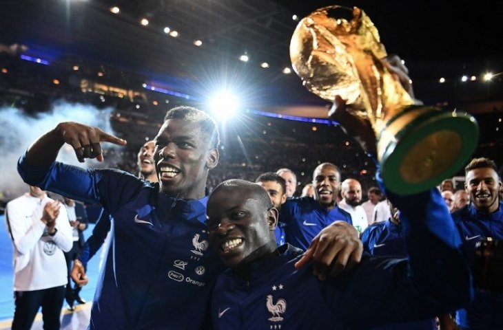 Paul Pogba (kiri) dan N'Golo Kante (kanan) saat merayakan keberhasilan mereka menjuarai Piala Dunia 2018 di depan para pendukungnya usai mengalahkan Belanda di ajang UEFA Nations League (Franck Fife/AFP)