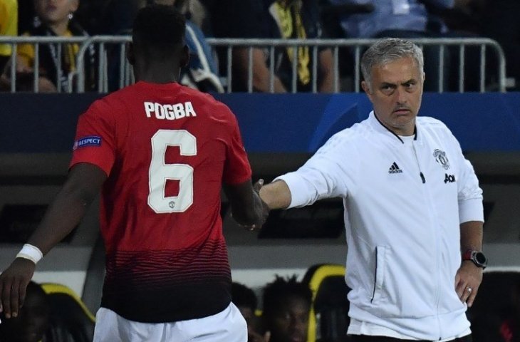 Pelatih Jose Mourinho berjabat tangan dengan Paul Pogba saat menggantinya (Alain Grosclaude/AFP)
