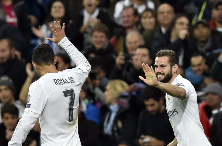 Pemain Real Madrid, Nacho Fernandez merayakan gol bersama Cristiano Ronaldo (kiri) saat babak penyisihan grup Liga Champions melawan Paris Saint-Germain (PSG) di Stadion Santiago Bernabeu (3/11/2015) (AFP)