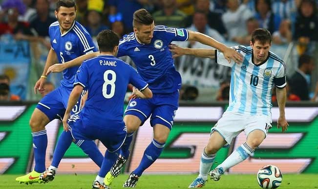 Lionel Messi berebut bola dengan pemain Bosnia pada fase grup Piala Dunia edisi 2014