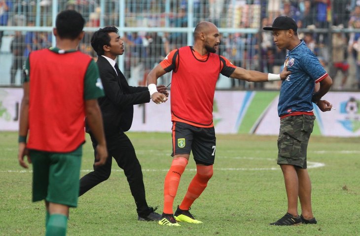 Pemain Persebaya Surabaya, Alfonsius Kelvan (tengah) bersitegang dengan oknum suporter Arema FC (Aremania) yang memasuki lapangan saat istirahat babak pertama dalam pertandingan Liga I GOJEK antara Arema FC melawan Persebaya Surabaya di Stadion Kanjuruhan, Malang, Jawa Timur, Sabtu (6/10) Dalam pertandingan tersebut Arema FC mengalahkan Persebaya dengan skor akhir 1-0. (ANTARA FOTO/Ari Bowo Sucipto)