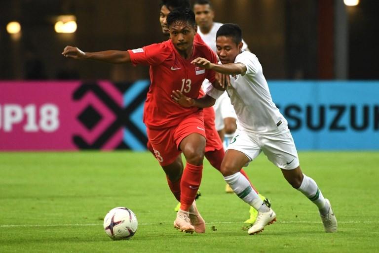 Evan Dimas terlbiat duel perebutan bola dengan gelandang Singapura, Izzdin Shafiq saat laga melawan Singarupa pada 9 November 2018 (Roslan Rahman/AFP)