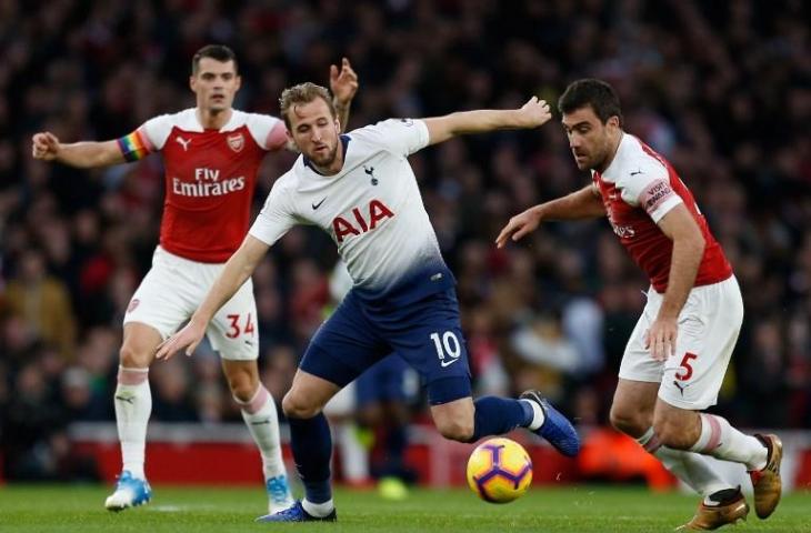 Harry Kane (tengah) berhadapan dengan bek Arsenal, Sokratis Papastathopoulos (kanan) saat duel di pekan ke-14 Liga Primer (Ian Kington/AFP)