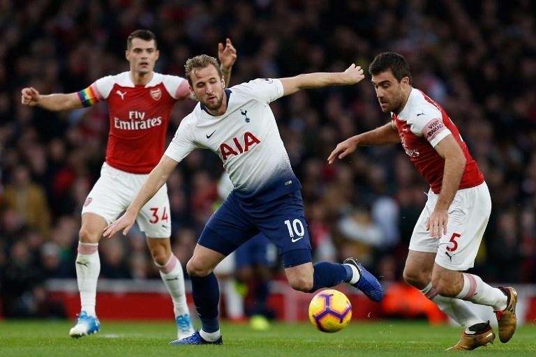 Harry Kane (tengah) berhadapan dengan bek Arsenal, Sokratis Papastathopoulos (kanan) saat duel di pekan ke-14 Liga Primer (Ian Kington/AFP)