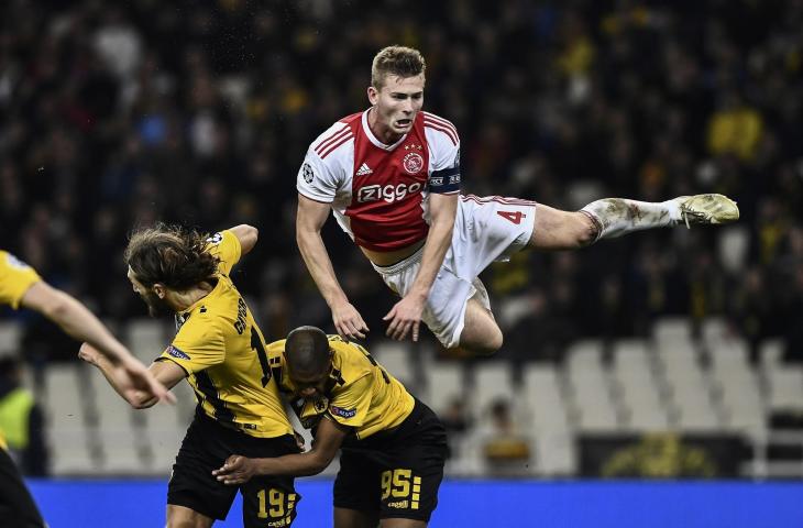 Pemain Ajax, Matthijs de Ligt saat duel udara dengan pemain AEK Athens Alef Saldanha dan Dmytro Chygrynskiy pada pertandingan Liga Champions di Athens Olympic Stadium, Athens. (27/11/2018) (AFP)