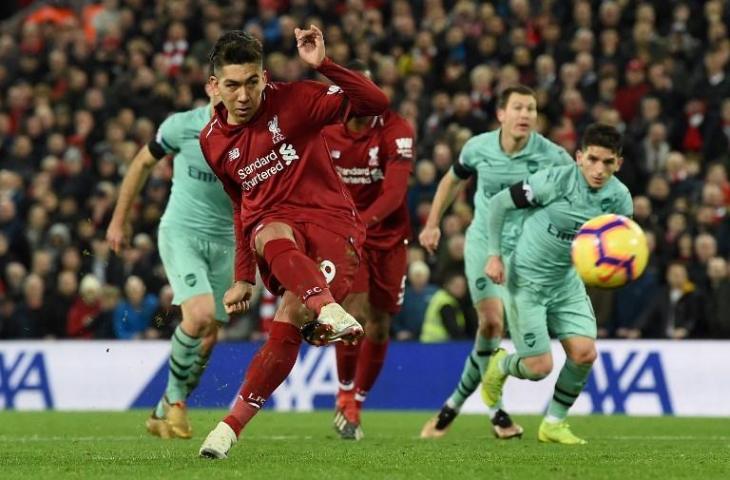 Roberto Firmino mencetak hat-trick di laga Liverpool kontra Arsenal salah satu golnya dicetak lewat tendangan penalti di babak kedua. Pada laga pekan ke-20 yang dihelat di Anfield itu Liverpool menang telak atas Arsenal 5-1, Minggu (30/12/2018). [PAUL ELLIS / AFP]