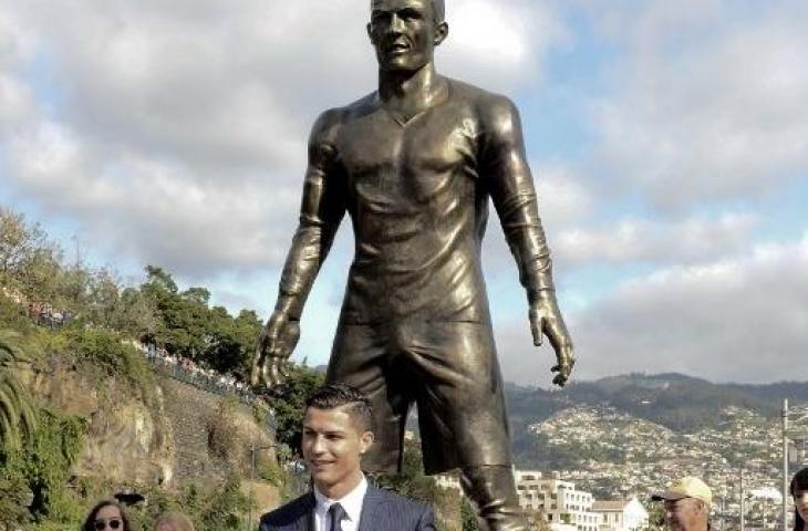 Cristiano Ronaldo berpose di depan patung replikanya di Hotel Pestana, Funchal, Portugal. [GREGORIO CUNHA / AFP]