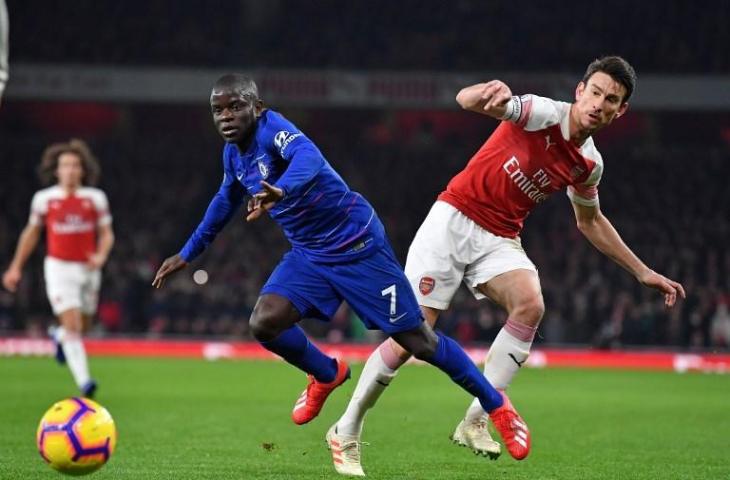 Pemain tengah Chelsea, N' Kante berebut bola dengan pemain bertahan Arsenal, Laurent Koscielny. Pada laga Liga Primer Inggris pekan ke-23 itu, Arsenal menang 2-0 atas Chelsea, Minggu (20/1/2019). [BEN STANSALL / AFP]