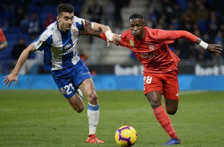 Pemain tengah Espanyol, Marc Roca berebut bola dengan penyerang muda Real Madrid Vinicius Junior. Pada laga jornada ke-21 La Liga, Senin (28/1/2019) yang dihelat di RCDE Stadium, Espanyol dibantai Real Madrid dengan skor 2-4. [JOSEP LAGO / AFP]