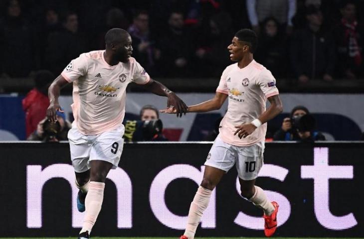 Romelu Lukaku disambut Marcus Rasford usai mencetak gol ke gawang Paris Saint Germain, Kamis (7/3/2019). Dalam laga leg kedua babak 16 besar Liga Champions tersebut Manchester United sukses comeback usai menundukkan tuan rumah dengan skor 1-3 dan menang agresifitas gol 3-3. [ANNE-CHRISTINE POUJOULAT / AFP]