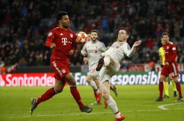 Aksi Andy Robertson (kanan) saat Liverpool mengalahkan Bayern Munich 3-1 di babak 16 besar Liga Champions, (13/3/2019). (ODD ANDERSEN / AFP)