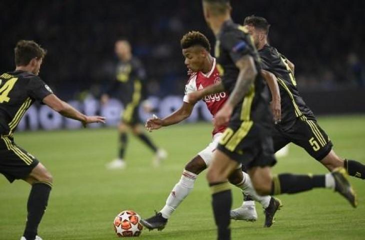 Aksi striker Ajax, David Neres (tengah) saat mencetak gol ke gawang Juventus dalam leg pertama perempatfinal Liga Champions di Johann Cruyff Arena, Kamis (11/4/2019) dini hari WIB. (JOHN THYS / AFP)