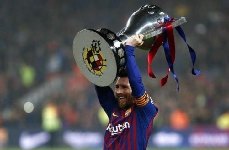 Striker Lionel Messi mengangkat trofi juara Liga Spanyol 2018/2019. (PAU BARRENA / AFP)