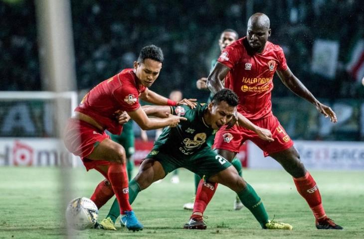 Penyerang Persebaya Osvaldo Haay mendapat kawalan ketat dari duet pemain belakang Kalteng Putra Wasyiat Hasbullah dan Onorionde Kughegbe John pada laga lanjutan Shopee Liga 1 2019. Kedua tim bermain imbang 1-1 pada laga di Stadion Gelora Bung Tomo malam ini (21/5). (Persebaya.id)