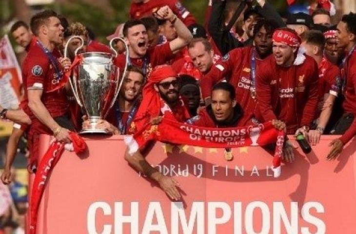 Bek Virgil van Dijk (tengah) bersama para pemain Liverpool lainnya melakukan parade juara Liga Champions dengan bus terbuka yang disambut oleh ribuan suporternya di jalan jalan kota. (Oli SCARFF / AFP)