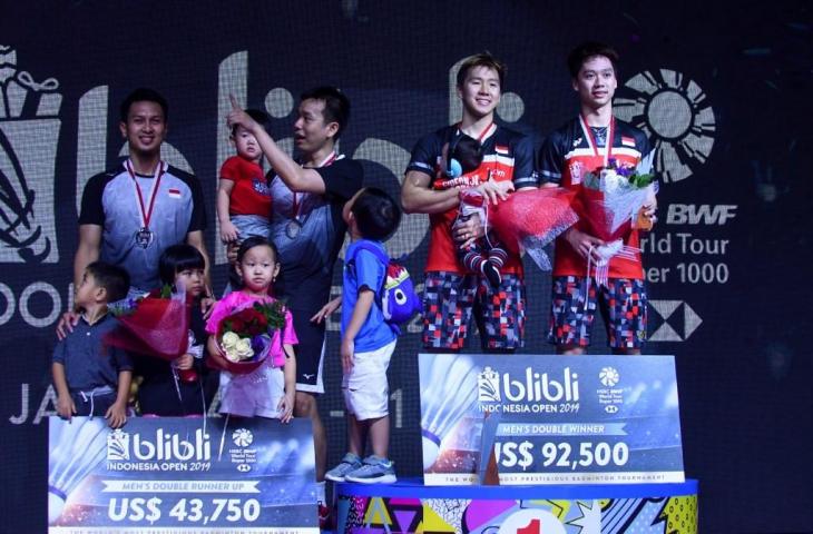 Kevin Sanjaya Sukamuljo dan Marcus Feraldi Gideon berpose di atas podium bersama Hendra Setiawan dan Mohammad Ahsan usai penyerahan medali final Indonesia Open 2019. [ADEK BERRY / AFP]