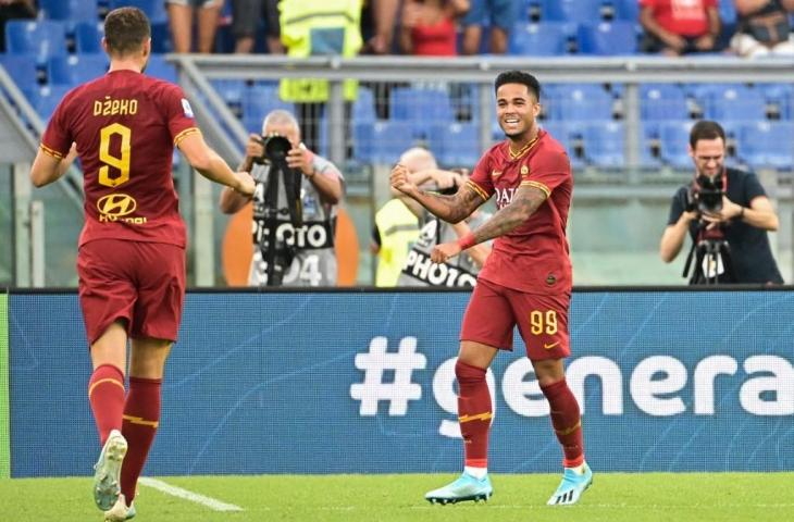 Justin Kluivert merayakan golnya ke gawang Sassuolo bersama Edin Dzeko. Pada laga lanjutan Serie A tersebut, AS Roma pesta gol ke gawang Sassuolo 4-2, Minggu (15/9/2019) malam. [VINCENZO PINTO / AFP]