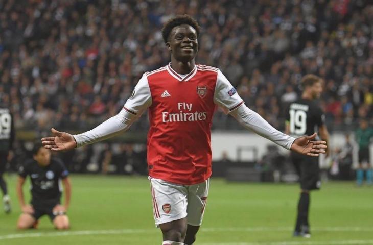 Gelandang Arsenla, Bukayo Saka melakukan selebrasi usai mencetak gol ke gawang Eintracht Frankfurt pada laga perdana Liga Europa 2019/20 di Stadion Commerzbank-Arena, Kamis (19/9/2019). [Instagram/@bukayosaka87]