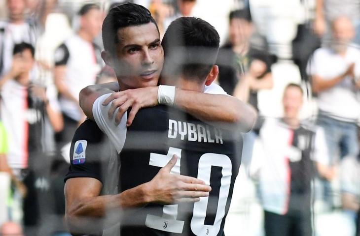 Cristiano Ronaldo memeluk Dybala usai mencetak gol ke gawang SPAL pada lanjutan Serie A, Sabtu (29/9/2019). [ANDREAS SOLARO / AFP]