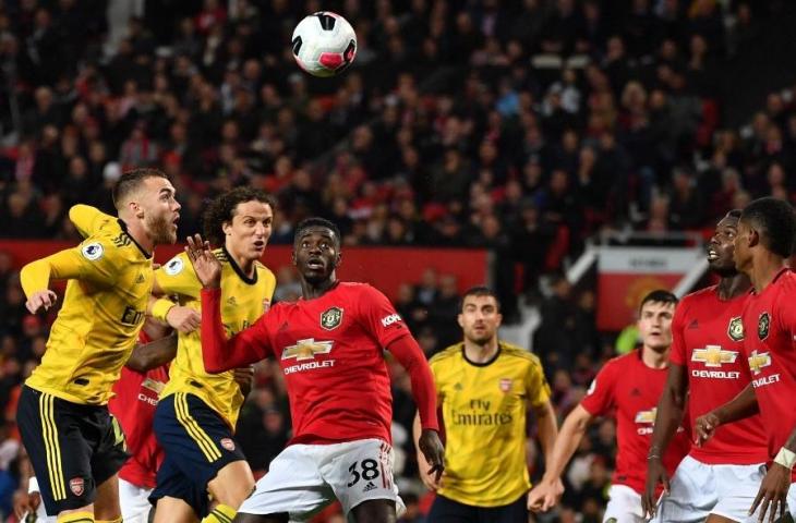 Pemain Manchester United, Axel Tuanzebe berebut bola dengan dua defender Arsenal, David Luiz dan Calum Chambers. Pada laga tersebut, Manchester United dan Arsenal bermain imbang 1-1, Selasa (1/10/2019) dini hari tadi. [PAUL ELLIS / AFP]