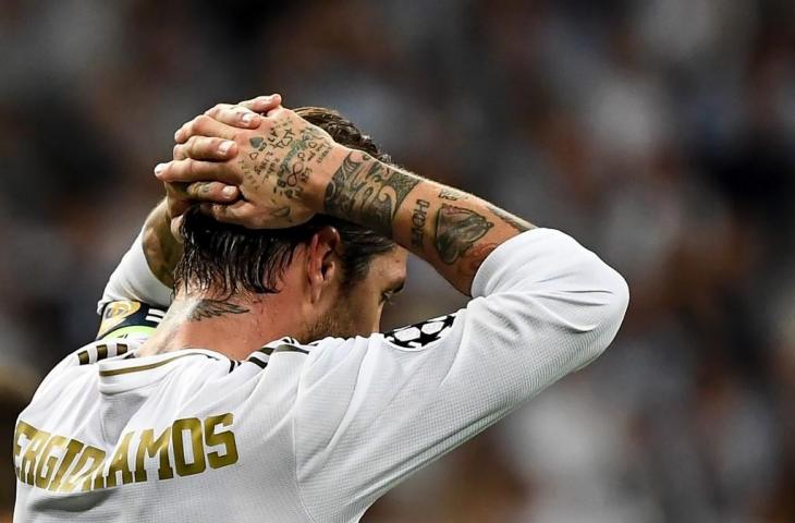 Bek Real Madrid Sergio Ramos tampak kecewa lantaran timnya gagal bermain maksimal saat menjamu Club Brugge pada lanjutan Liga Champions, Rabu (2/10/2019) dini hari tadi. [PIERRE-PHILIPPE MARCOU / AFP]