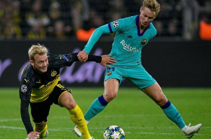 Penyerang Barcelona, Frenkie de Jong berebut bola dengan pemain Borussia Dortmund, Julian Brandt pada laga lanjutan Liga Champions beberapa waktu lalu. [SASCHA SCHUERMANN / AFP]