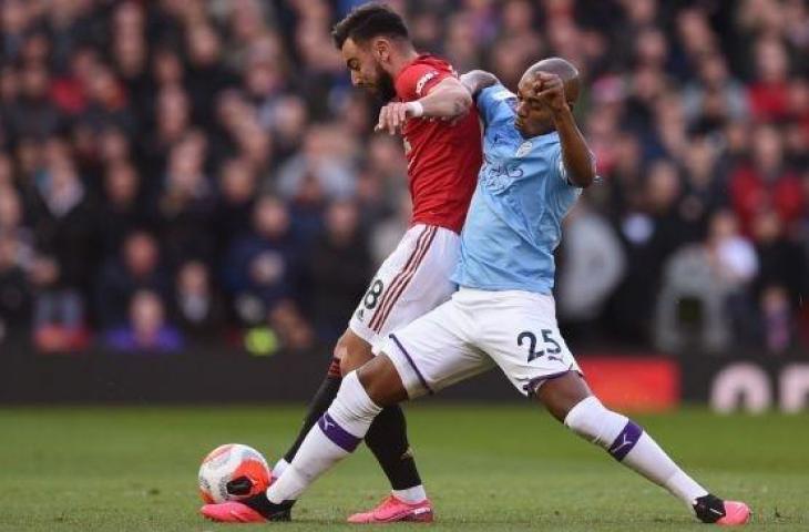 Gelandang serang Manchester United, Bruno Fernandes (kiri) berduel dengan gelandang bertahan Manchester City, Fernandinho pada laga Liga Inggris 2019/2020 di Old Trafford, Manchester, Senin (9/3/2020) dini hari WIB. [AFP]