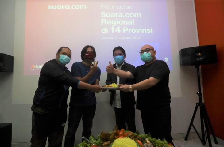 CEO PT Arkadia Digital Media Tbk Wiliam Martaputra (kanan) dan COO PT Arkadia Digital Media Tbk sekaligus Pemimpin Redaksi Suara.com Suwarjono, menyerahkan potongan tumpeng kepada dua koordinator dan penanggung jawab daerah saat acara Peluncuran Suara.com Regional di 14 Provinsi di kantor redaksi di Jakarta, Jumat (28/8/2020). (Suara.com/Angga Budhiyanto).