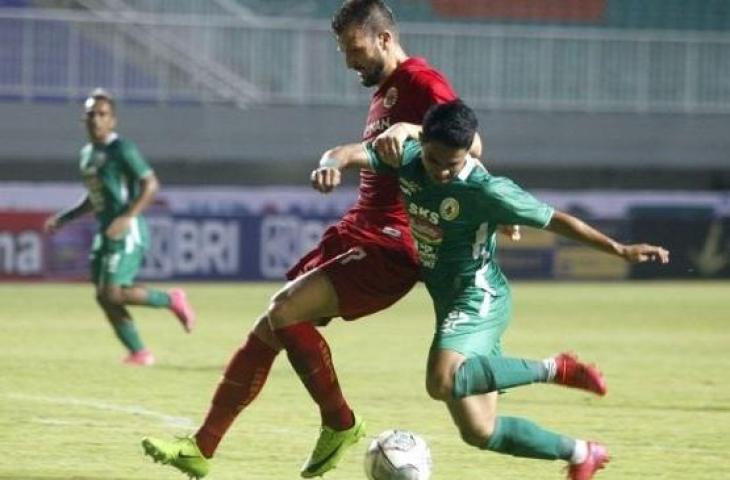 Winger PSS Sleman, Irkham Mila (kanan) berduel dengan bek Persija Jakarta, Marco Motta dalam laga Liga 1 2021 di Stadion Pakansari, Bogor, Minggu (5/9/2021) malam. [ANTARA FOTO/Yulius Satria Wijaya]