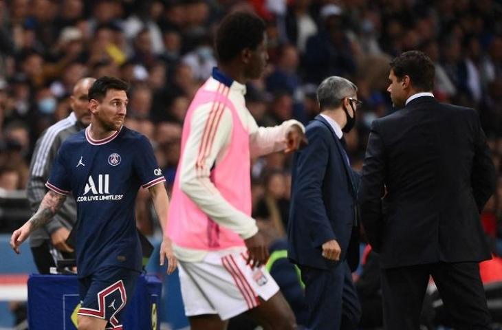 Lionel Messi (kiri) memperlihatkan gesture kebingunan yang ditujukan kepada pelatih PSG Mauricio Pochettino pasca diganti di tengah laga PSG vs Lyon dalam lanjutan Ligue 1 Prancis di Parc des Princes, Paris, Senin (20/9/2021) dini hari WIB. (FRANCK FIFE / AFP)