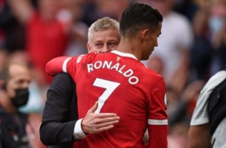 Megabintang Manchester United, Cristiano Ronaldo (kanan) berpelukan dengan sang pelatih, Ole Gunnar Solskjaer seusai laga Liga Inggris kontra Newcastle United di Old Trafford, Manchester, Sabtu (11/9/2021) malam WIB. [OLI SCARFF / AFP]