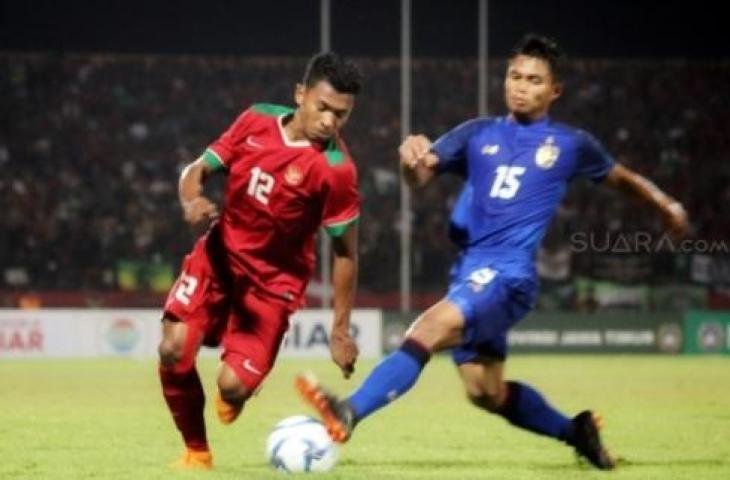 Pemain Timnas Rifad Marasabessy (kiri), mencoba melewati hadangan pemain Thailand, Sampan Kesi, dalam laga yang berakhir 1-2 untuk kemenangan Thailand di penyisihan terakhir Grup A Piala AFF U-19 2018 di Stadion Delta Sidoarjo, Jawa Timur, Senin (9/7). [Suara.com/Dimas Angga P]