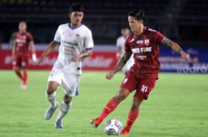 Striker Persis Solo, Irfan Bachdim berusaha melewati adangan pemain PSIM Yogyakarta, Ahmad Baasith dalam lanjutan Liga 2 musim 2021 di Grup C di Stadion Manahan, Senin (15/11/2021). [Suara.com/Ronald Seger Prabowo]