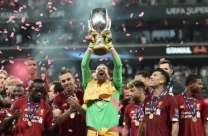 Kiper Liverpool Adrian mengangkat trofi setelah menjuara Piala Super Eropa setelah mengalahkan Chelsea lewat adu penalti. OZAN KOSE / AFP