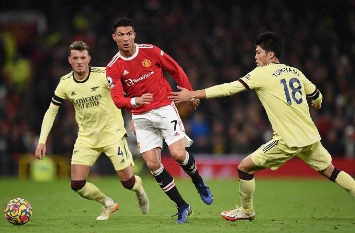 Pemain Manchester United Cristiano Ronaldo dihadang pemain Arsenal Ben White dan Takehiro Tomiyasu.pada laga lanjutan Liga Inggris di Stadion Old Trafford, Jumat (3/12/2021) dini hari WIB. (AFP/Oli SCARFF)