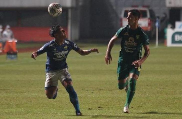 Pemain Persib Bandung, Henhen Herdiana (kiri) berebut bola dengan pemain Persebaya Surabaya, Bruno Moreira dalam laga BRI Liga 1 di Stadion Maguwoharjo, Sleman, Rabu (8/12/2021) malam. [ANTARA FOTO/Andreas Fitri Atmoko]