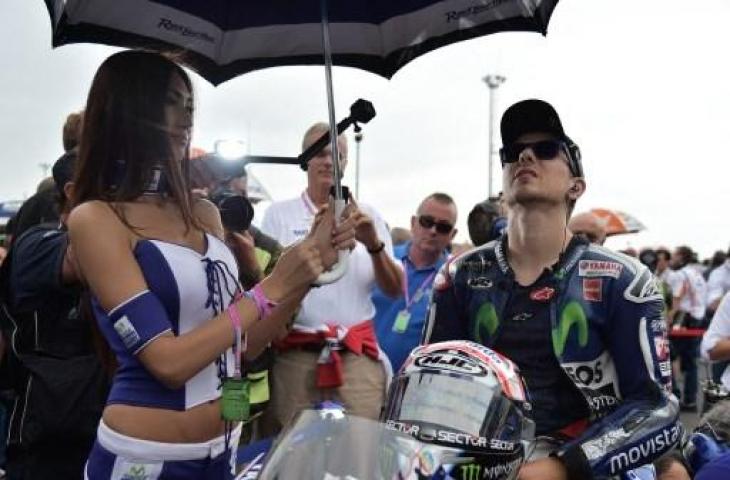 Potret Jorge Lorenzo bersama umbrella girl di MotoGP San Marino pada 2015. (VINCENZO PINTO / AFP)