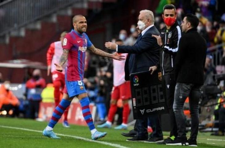 Potret Dani Alves dengan pelatih Barcelona, Xavi Hernandez. (LLUIS GENE / AFP)