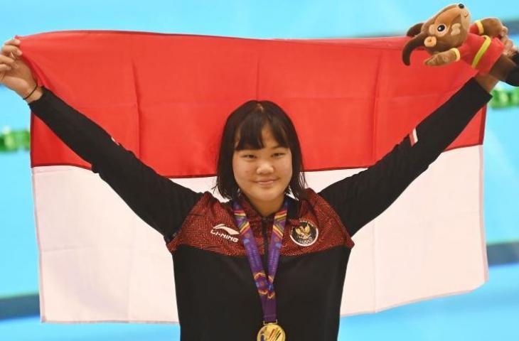 Perenang Indonesia Flairene Candrea Wonomiharjo membentangkan bendera Merah Putih usai upacara pengalungan medali nomor renang 100 meter gaya punggung putri SEA Games 2021 Vietnam di Aquatic Sport Palace, Hanoi, Vietnam, Selasa (17/5/2022). . ANTARA FOTO/Aditya Pradana Putra