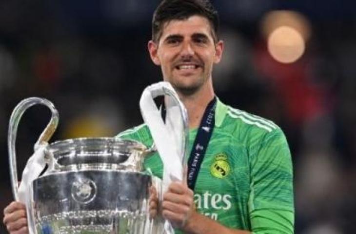 Penjaga gawang Real Madrid Belgia Thibaut Courtois mengangkat trofi Liga Champions setelah kemenangan Madrid dalam pertandingan sepak bola final Liga Champions UEFA antara Liverpool dan Real Madrid di Stade de France di Saint-Denis, utara Paris, pada 28 Mei 2022. Paul ELLIS/AFP