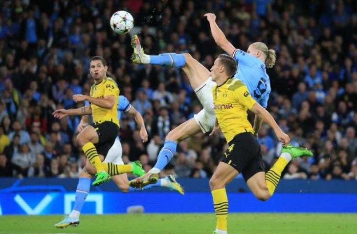 Striker Manchester City asal Norwegia Erling Haaland (tengah) melepaskan tembakkan spektakuler untuk membobol gawang Borussia Dortmund dalam matchday kedua Grup G Champions League (Liga Champions) 2022-2023 antara Man City vs Dortmund di Stadion Etihad, Manchester pada Kamis (15/9/2022) dini hari WIB. Man City menang 2-1. Lindsey Parnaby / AFP.