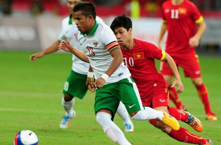 Manahati Lestusen (kiri) berebut bola melawan Cong Phuong Nguyen dari Vietnam (kanan) dalam perebutan medali perunggu sepak bola putra pada SEA Games ke-28 di Singapura pada 15 Juni 2015. (AFP/MOHD FYROL)