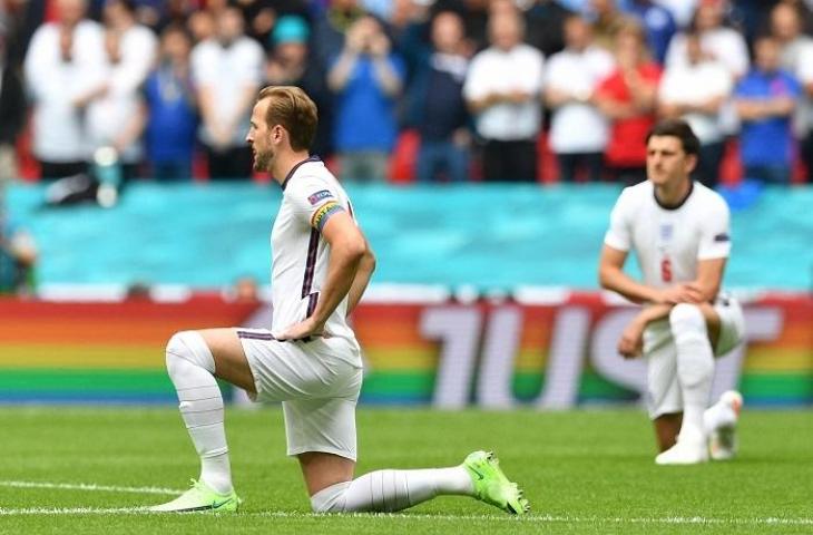 Pemain Timnas Inggris Harry Kane dan Harry Maguire melakukan ritual berlutut sebagai pesan anti rasisme. (AFP/Justin Tallis)