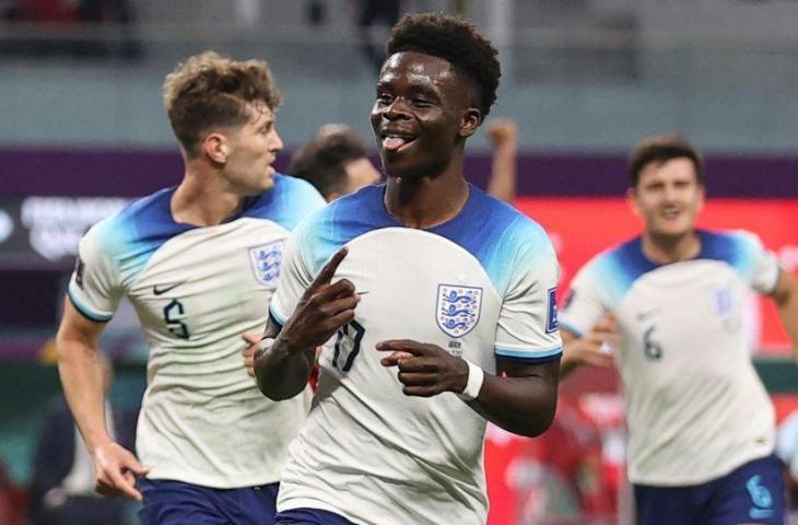 Penyerang Inggris Bukayo Saka merayakan gol kedua timnya selama pertandingan sepak bola Grup B Piala Dunia 2022 antara Inggris dan Iran di Stadion Internasional Khalifa di Doha, Qatar, Senin (21/11/2022). [ADRIAN DENNIS / AFP]